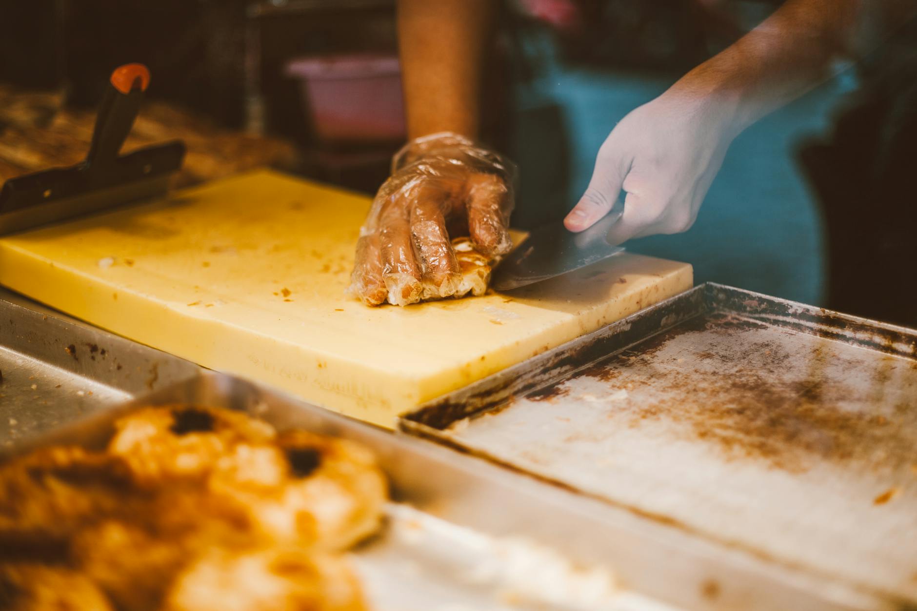 person slicing bread on chopping board